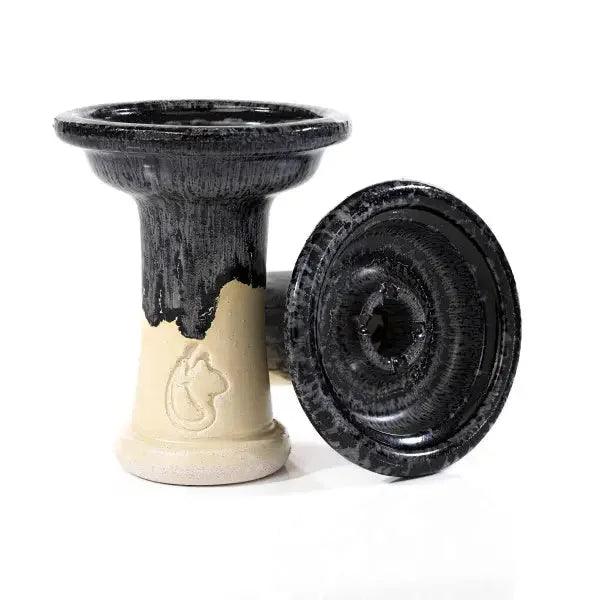 Dschinni Shisha Phunnel Royal Schamottstein Negro in schwarz. Es ist ein stehender und ein liegender Phunnel abgebildet. Das Dschinni Symbol ist zu sehen.